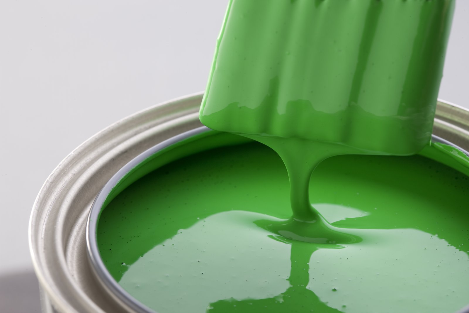 Green soy-based paint in an open can.