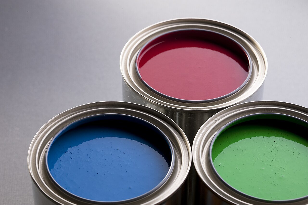 Three open cans of soy-based paint.