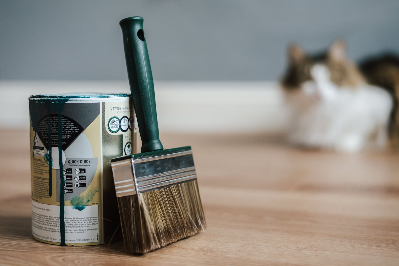 A paintbrush beside a paint can during a home project.
