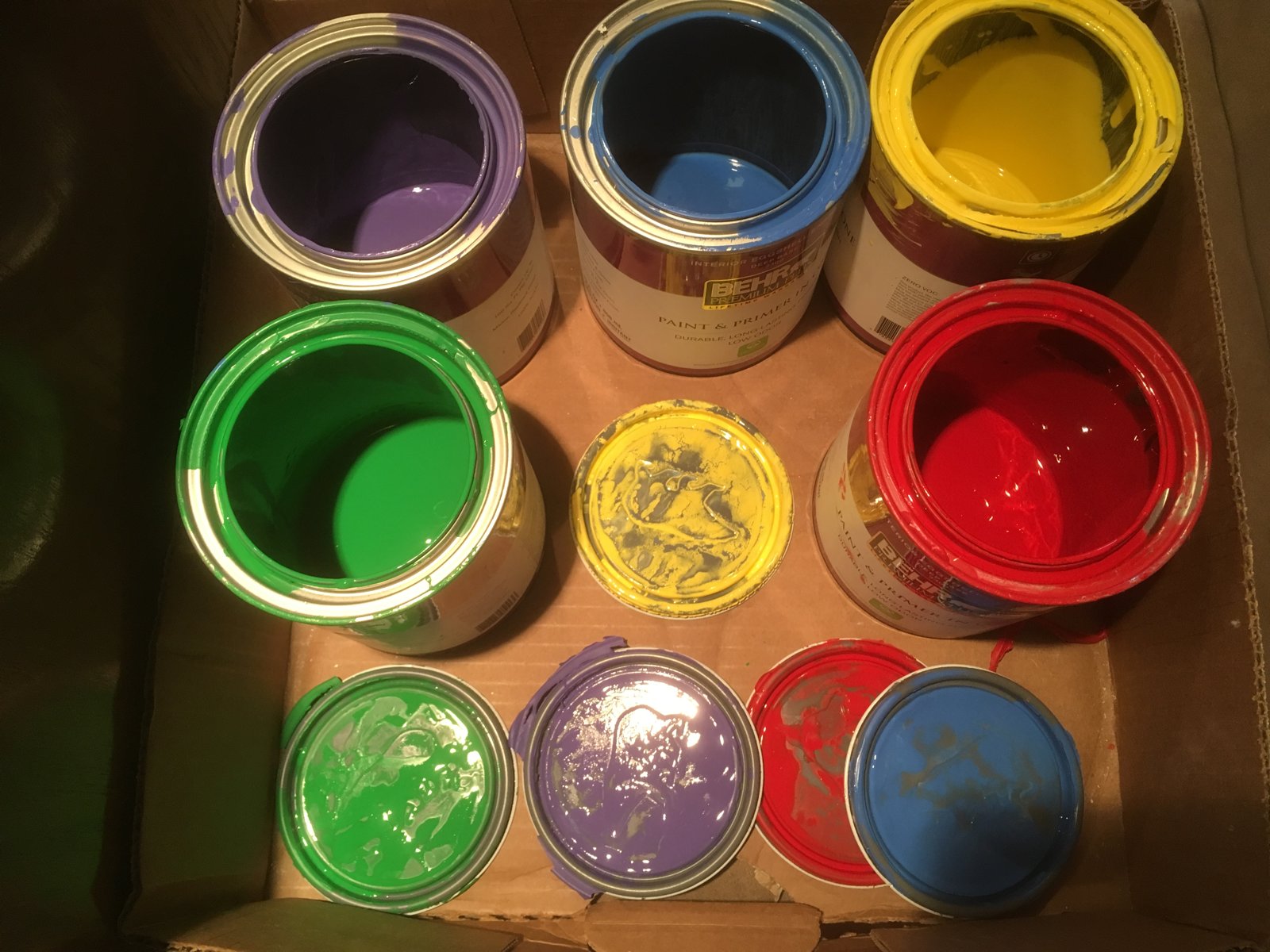 Open paint cans and matching lids, photographed in 2019.
